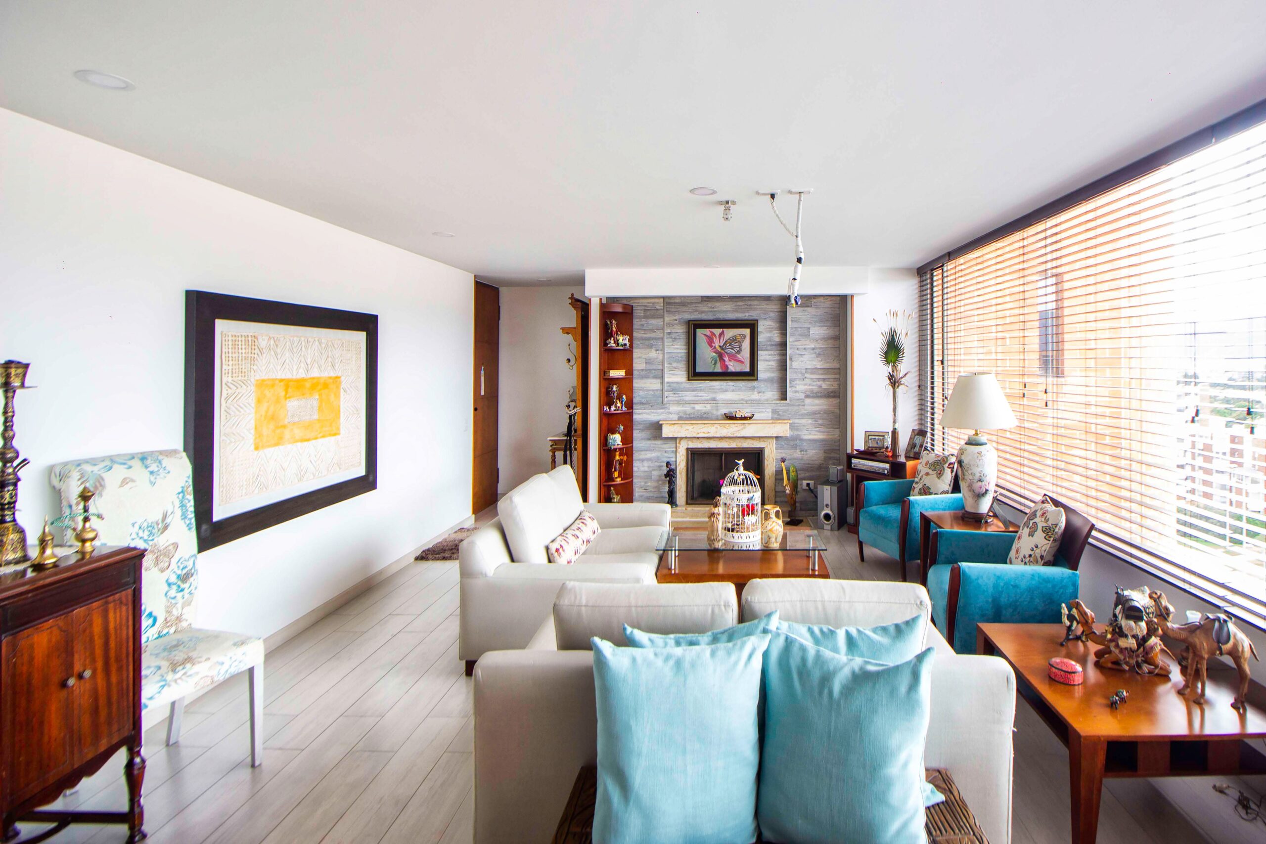Bright living room with large windows and blue accent chairs